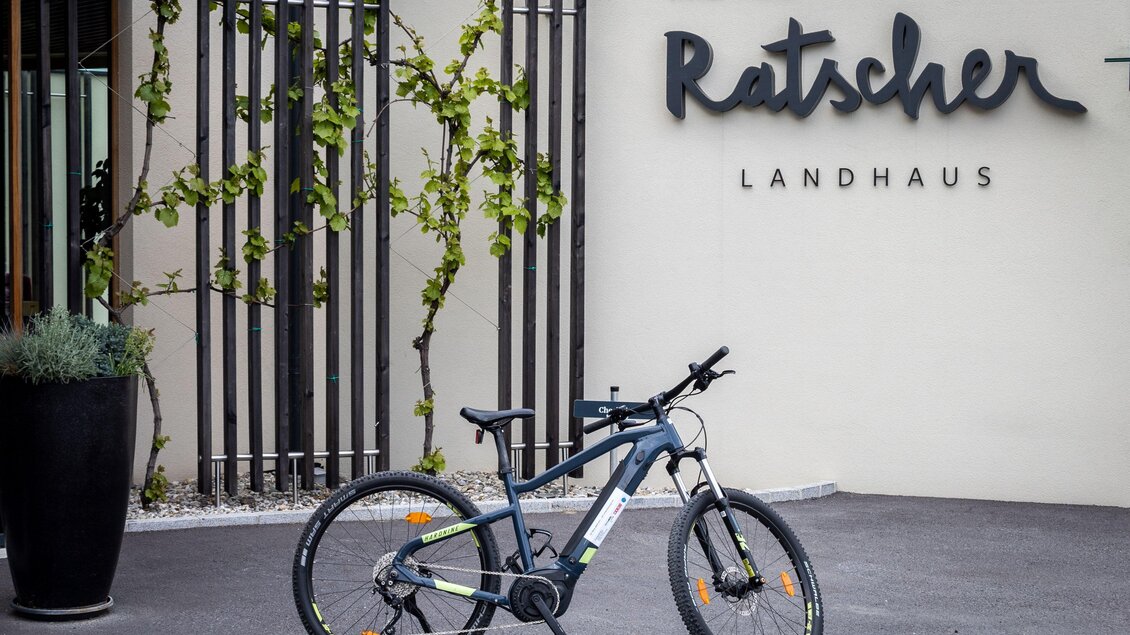 Ein modernes Fahrrad steht vor dem Hotel Ratscher Landhaus. Im Hintergrund sieht man die elegante Fassade des Hotels mit Pflanzen. | © Ratscher Landhaus