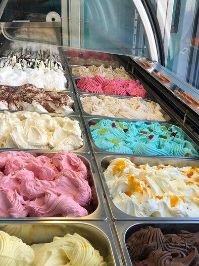 Eine Eistheke mit verschiedenen Eissorten in bunten Farben. Die verschiedenen Geschmäcker sind kreativ angeordnet und laden zum Probieren ein. | © Anita Kainz