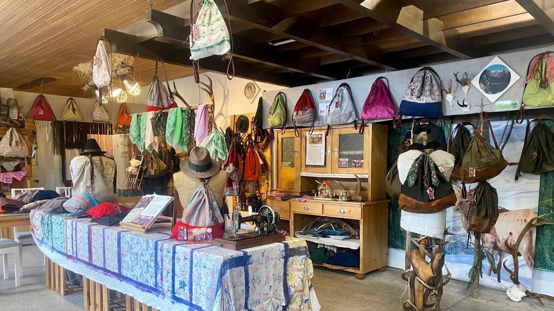 Ein kreativer Laden mit vielen Taschen, die an der Wand hängen. Im Vordergrund steht ein Tisch mit verschiedenen Accessoires und Stoffen. | © TVB Ausseerland/Bettina Scheck