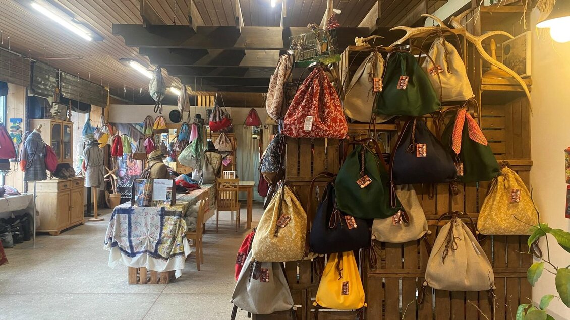 Ein gemütliches Geschäft mit vielen bunten Taschen und Accessoires. Die Wände sind mit verschiedenen Modellen dekoriert. | © TVB Ausseerland/Bettina Scheck