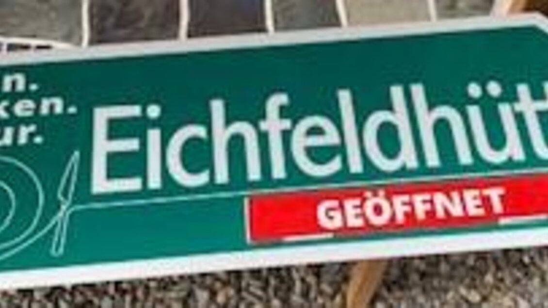 Ein Schild der Eichfeldhütte, das auf Essen, Trinken und Kultur hinweist. Es zeigt an, dass die Hütte geöffnet ist. | © Marcus Auer