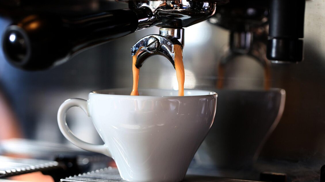 Eine Tasse Kaffee wird gerade von einer Espressomaschine frisch zubereitet. Goldbrauner Espresso läuft in die weiße Tasse. | © Pixabay