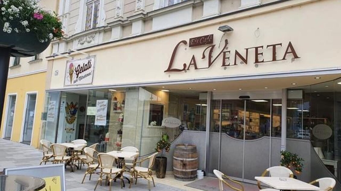 Ein einladendes Eiscafé mit Tischen im Freien. Die Fassade ist hell und modern gestaltet. | © Eiscafé Pizzeria La Veneta