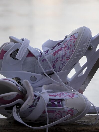 Zwei Schlittschuhe auf Holzbank vor gefrorener Eisfläche in Graz.  | © TV Region Graz - Jimmy Lunghammer