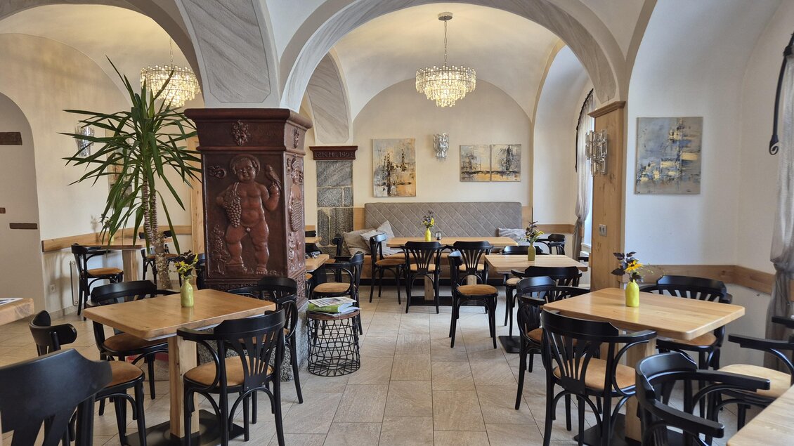 Ein gemütliches Restaurant mit Holzstühlen und Tischen. Die elegante Decke und die Kronleuchter schaffen eine warme Atmosphäre. | © TV Murau