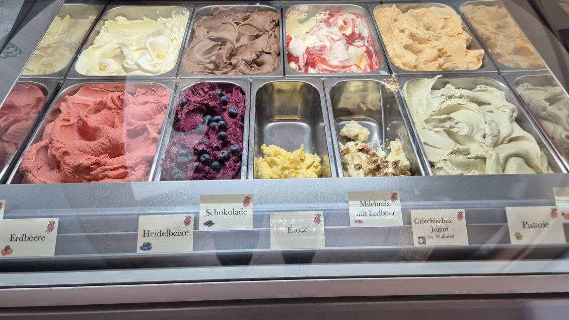 Eine Eistheke mit verschiedenen Sorten Eis in bunten Farben. Die Eissorten sind sorgfältig in Behältern angeordnet und beschriftet. | © TV Murau