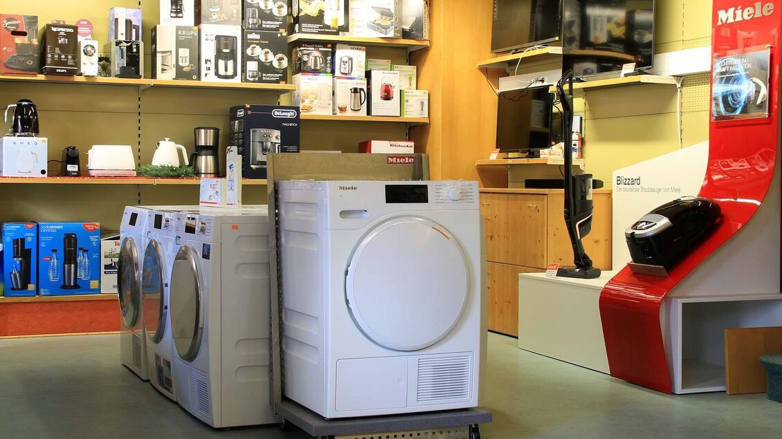 Ein Geschäft für Haushaltsgeräte mit Waschmaschinen und verschiedenen Elektrogeräten. Im Hintergrund sind weitere Produkte auf Regalen platziert. | © Hentschel