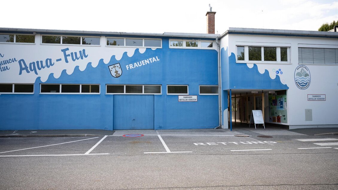 Ein modernes Gebäude mit der Beschriftung "Aqua-Fun" in blauen Farben. Der Eingangsbereich ist sichtbar und es gibt Parkplätze vor dem Gebäude. | © Schilcherland Steiermark