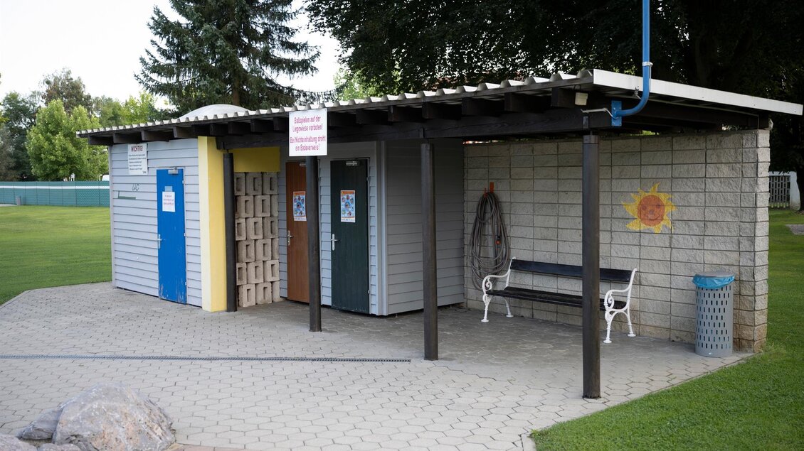 Ein einfaches Gebäude mit zwei Eingängen und einer Überdachung. Vor dem Gebäude gibt es eine Bank und Mülltonne in einem gepflegten Außenbereich. | © Schilcherland Steiermark