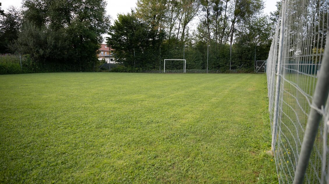 Ein kleiner Fußballplatz mit grünem Rasen und einem Tor im Hintergrund. Umgeben von Bäumen und einem Zaun. | © Schilcherland Steiermark