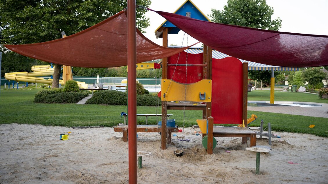 Ein Spielplatz mit bunten Spielgeräten und Sonnenschutz. Der Sandbereich lädt Kinder zum Spielen ein. | © Schilcherland Steiermark
