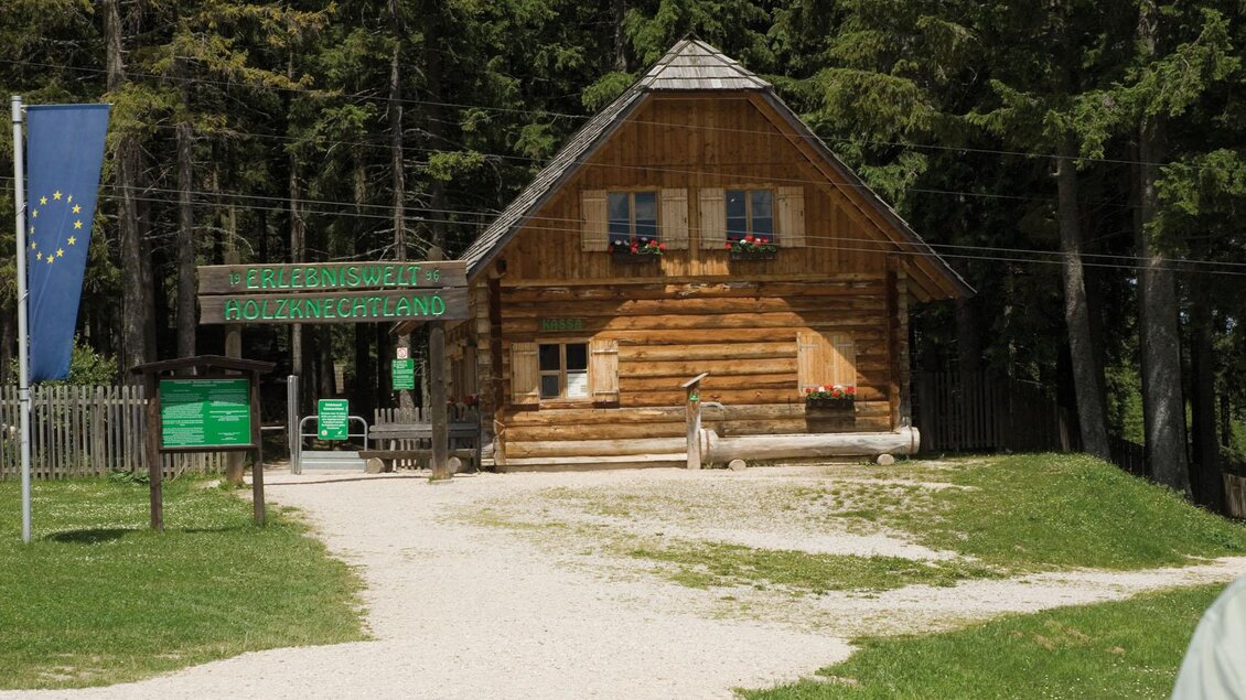 Ein traditionelles Holzhaus inmitten von Bäumen. Der Weg führt zu einem freundlichen Empfangsbereich. | © TV Hochsteiermark