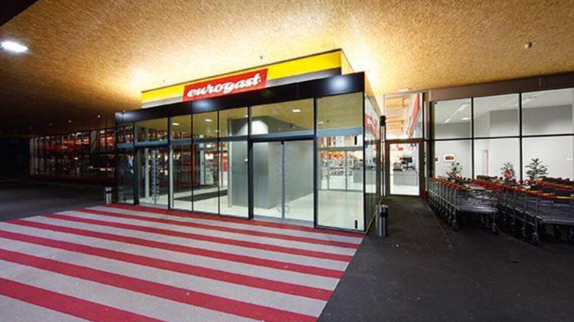 Eingangsbereich des Eurogast-Marktes mit Glasfront, automatischen Schiebetüren und rot-weiß gestreiftem Gehweg. | © Eurogast Schladming