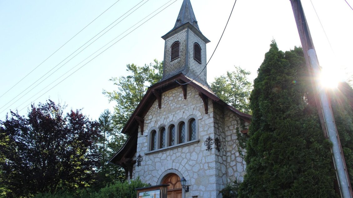 Eine kleine Kirche aus Stein mit einem spitzen Turm. Der Raum rundherum ist von grünen Bäumen und Sträuchern umgeben. | © TVB Ausseerland - Salzkammergut-Viola Lechner