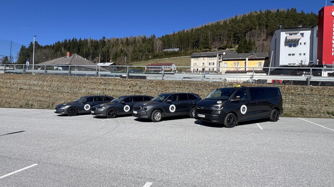 Vier Autos parken auf einem asphaltierten Parkplatz. Im Hintergrund sind Bäume und Gebäude sichtbar. | © Taxi Schweighofer KG