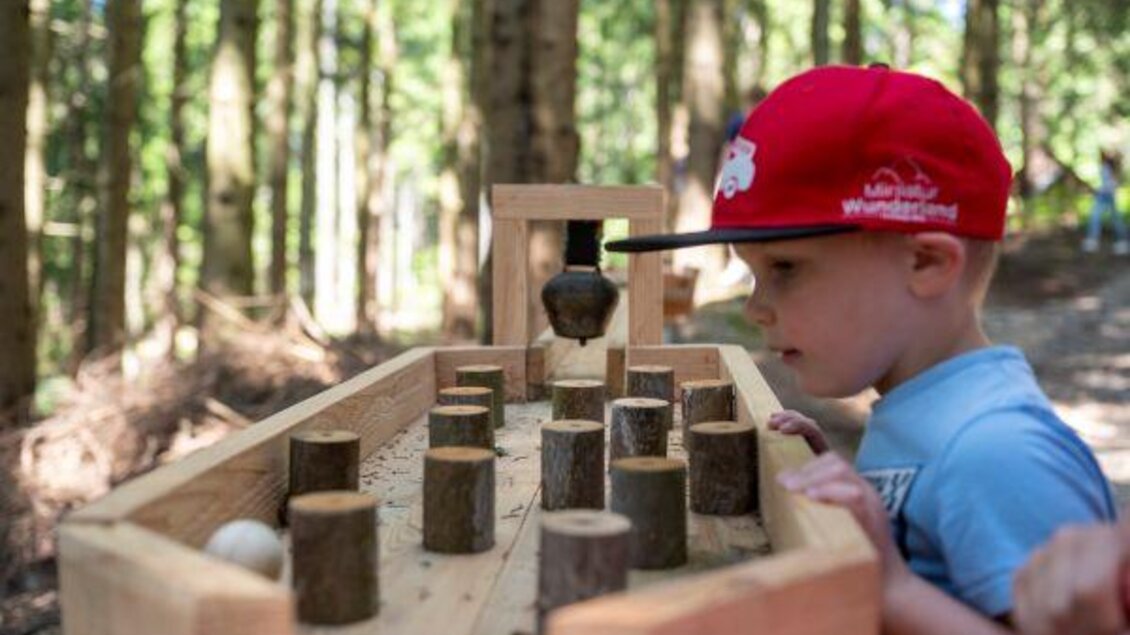 Ein Junge beim Spielen im Wald. | © Familienhotel Berger