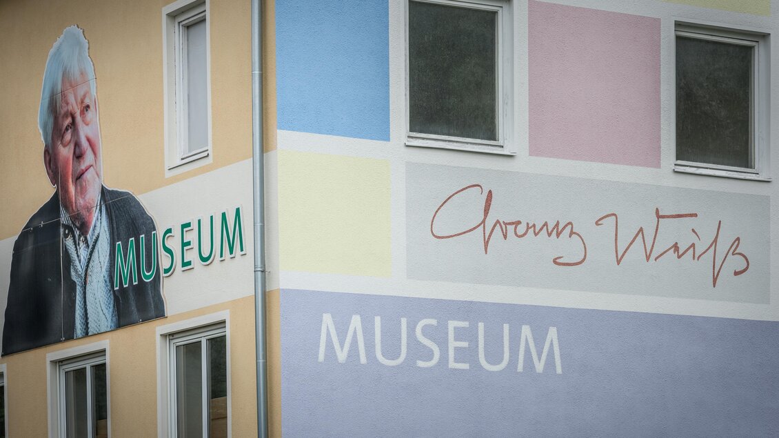 Franz Weiß Museum in Voitsberg mit Künstlerporträt, Signatur, Schriftzügen und farbig gestalteter Fassade | © TV Region Graz - Die Abbilderei