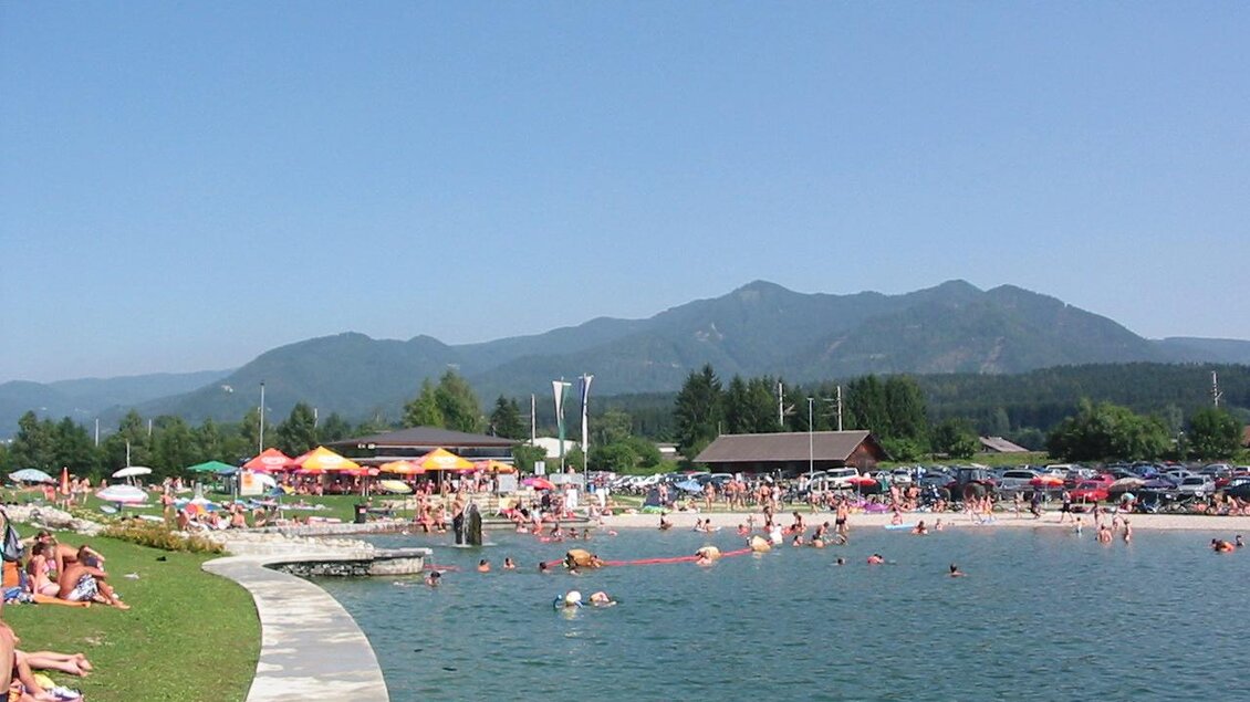 Ein schöner Badesee mit vielen Menschen, die im Wasser schwimmen und sich sonnen. Im Hintergrund sind Berge und Bäume zu sehen. | © Gemeinde Krieglach