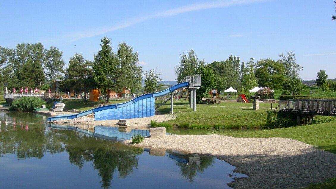 Ein schöner Park mit einem Wasserbecken und einer Rutsche. Grüne Wiesen und Bäume umgeben den Bereich, ideal für Familien. | © Gemeinde Großsteinbach