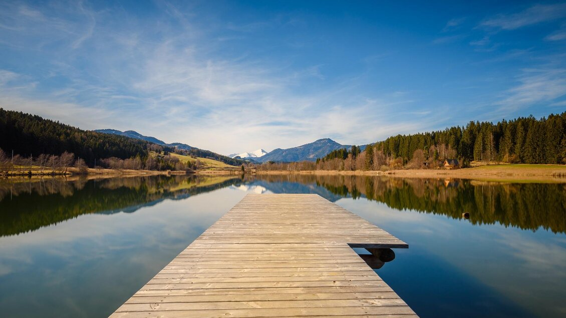 Ein schöner Steg am ruhigen See, umgeben von Bergen und Bäumen. Der Himmel ist klar und strahlend blau. | © Tourismusverband Murau