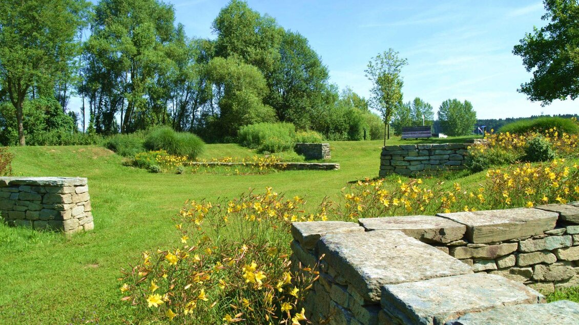 Eine weitläufige Wiese mit üppigem Grün und bunten Blumen. Im Hintergrund sind Bäume und ein klarer blauer Himmel zu sehen. | © Kurkommission Bad Blumau