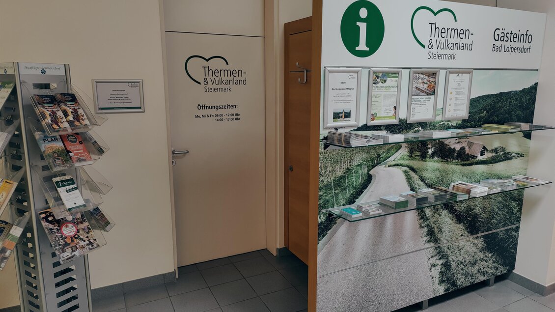 Ein Informationsbereich mit einem großen Schalter für Gäste und einem Informationsstand zu Thermen und Vulkanland Steiermark. Der Raum ist hell und freundlich gestaltet. | © Thermen- & Vulkanland