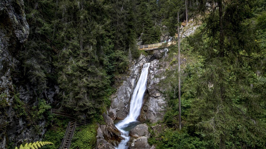 Ein schöner Wasserfall, der inmitten von grünen Wäldern fließt. Der Weg führt vorbei an den Felsen und der üppigen Vegetation. | © Holzwelt Murau