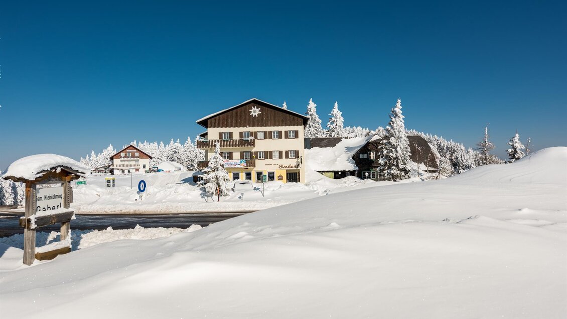 <p>Gaberlhaus in verschneiter Winterlandschaft mit tiefem Schnee und klarem Himmel.  | © TV Lipizzanerheimat | Die Abbilderei
