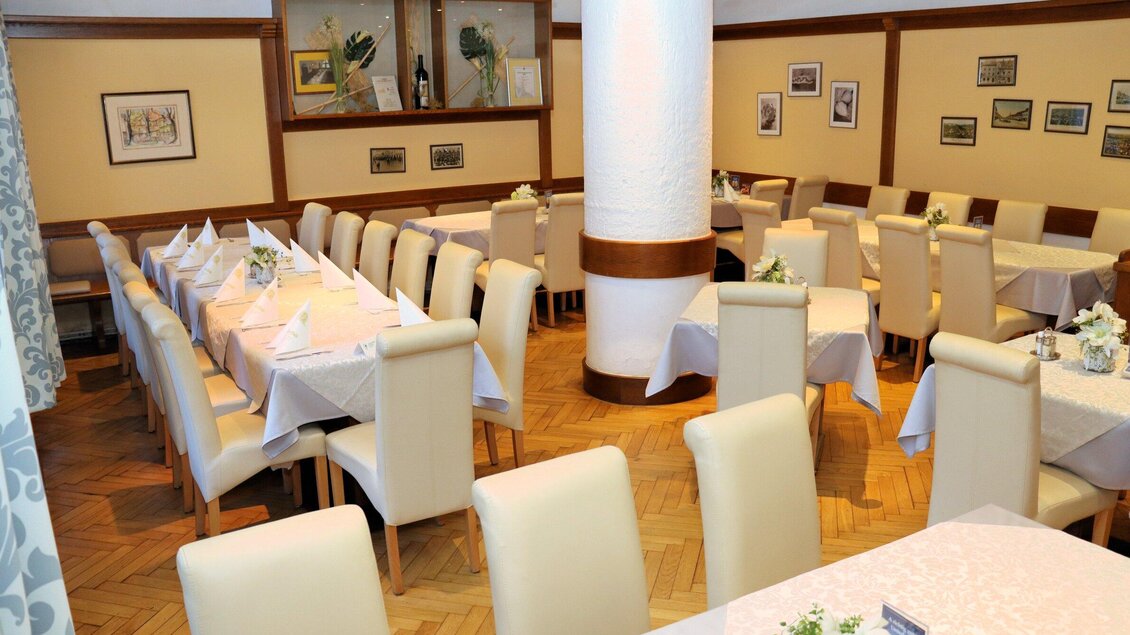 Innenraum mit gedeckten Tischen, weißen Stühlen und traditioneller Einrichtung im Gasthaus zur Alten Post in Voitsberg. | © Familie Prettenthaler