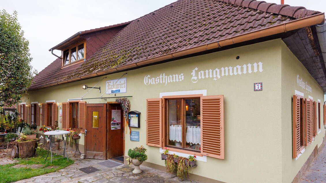 Außenansicht des Gasthauses Eckwirt in Ligist mit Eingangsbereich, Fenstern und Gastgarten. | © TV Region Graz-Harry Schiffer