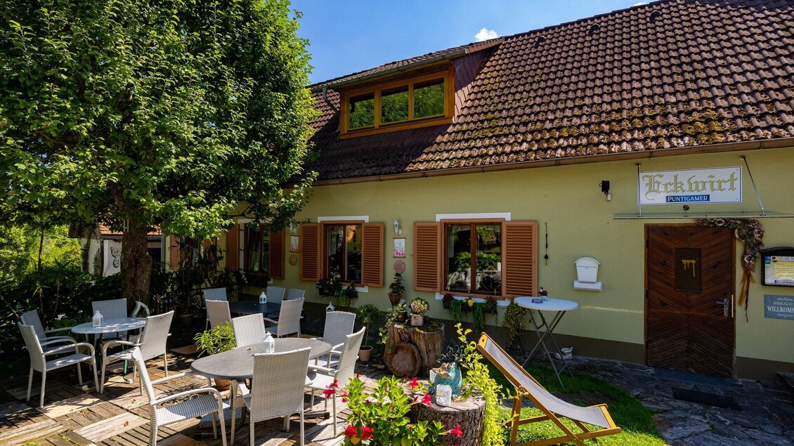 Gastgarten mit Sitzplätzen vor dem Gasthaus Eckwirt in Ligist an einem sonnigen Tag. | © TV Region Graz-Harry Schiffer