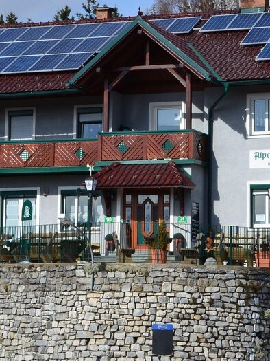 Gasthaus Eckwirt in Graden mit Solaranlage auf dem Dach und Gastgarten vor Natursteinmauer. | © Eckwirt-Steirer