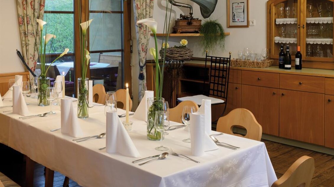 Stilvoll gedeckter Tisch in der Gaststube des Gasthauses Jägerwirt in Graden mit Blick ins Grüne. | © Familie Wipfler