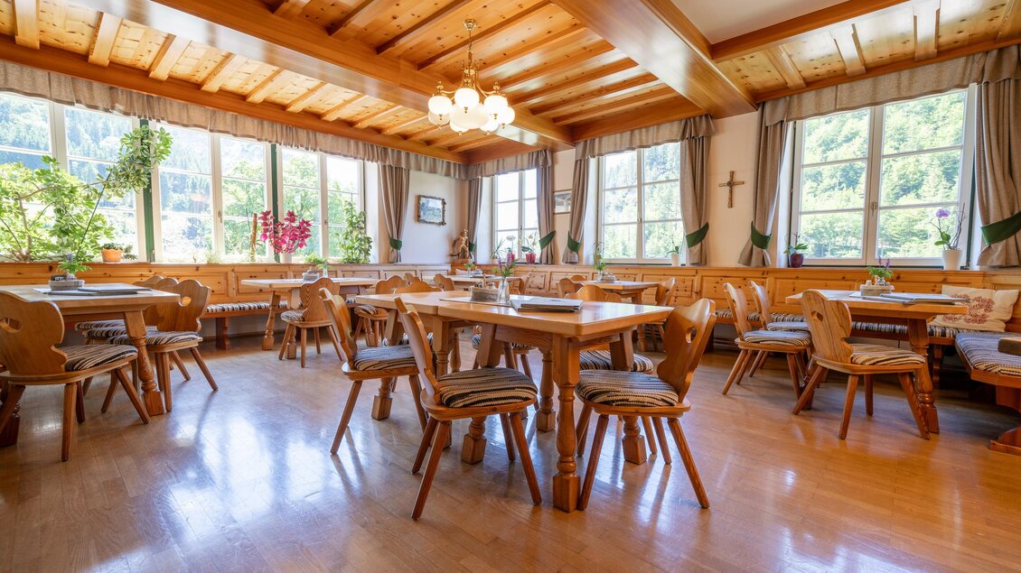 Der gemütliche Speisesaal vom Gasthaus Lodenwalker mit Holzstühlen und -tischen. Große Fenster sorgen für viel Tageslicht und Blick auf die natürliche Umgebung. | © Lodenwalker Ramsau