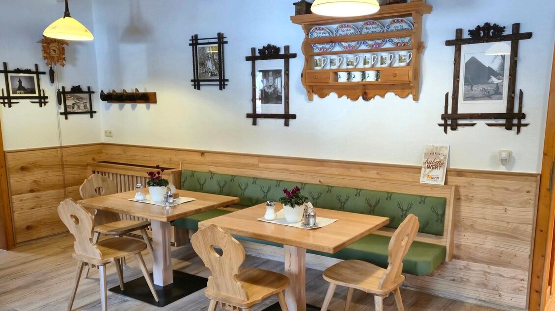 Ein gemütliches Restaurant mit Holztischen und Stühlen. An den Wänden hängen dekorative Bilder und der Raum ist freundlich beleuchtet. | © Gasthaus Murbodenhüttl