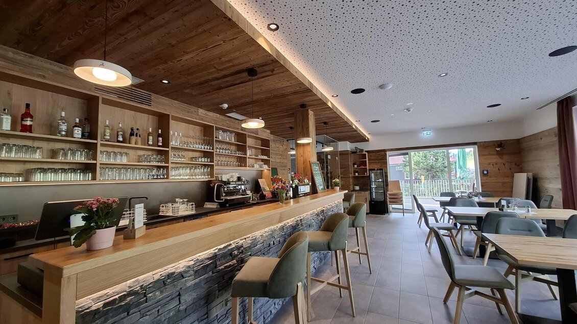 Barbereich des Gasthauses Packerhöhe mit Holztheke, Sitzplätzen und Restaurantbereich in Hirschegg-Pack. | © Region Graz_Astrid Lackner