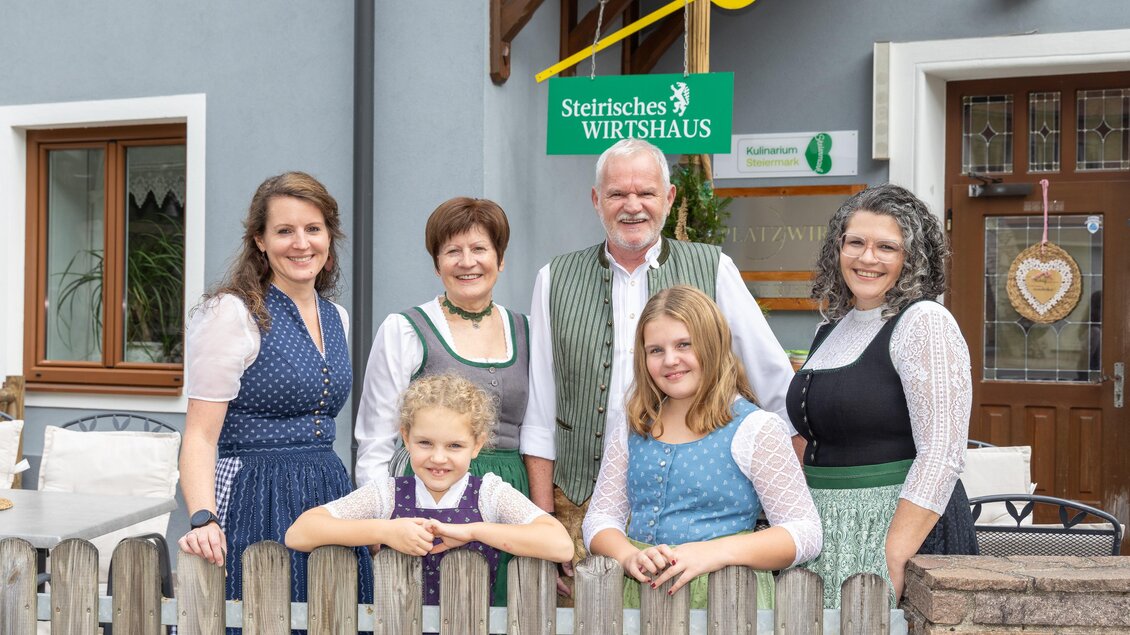 Gastgeberfamilie in steirischer Tracht vor dem Eingang des Wirtshauses Platzwirt in Graden.  | © Region Graz, Harry Schiffer
