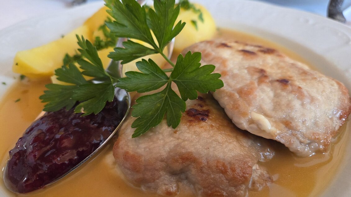 Fleischgericht mit Bratensaft, Preiselbeeren und Petersilienkartoffeln angerichtet  beim Platzwirt in Graden. | © Platzwirt, Barbara Reiner