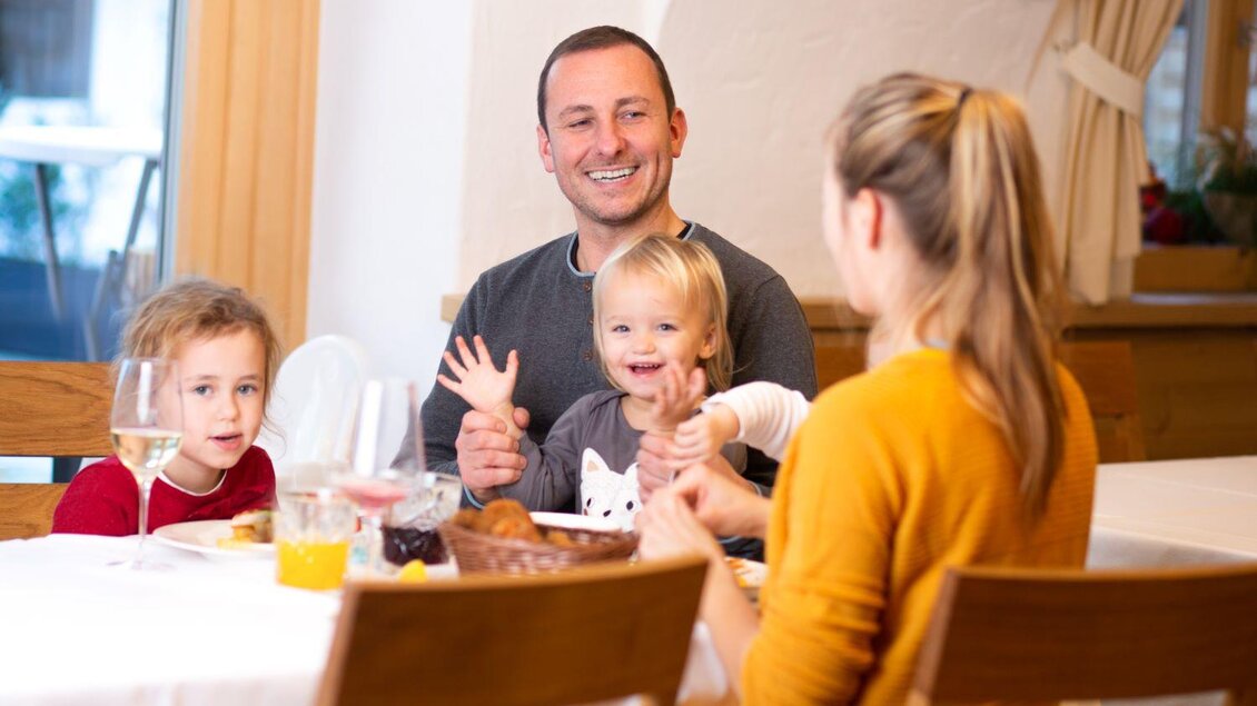 Zu sehen ist eine Familie mit Kindern am gedeckten Tisch.  | © Gasthaus Strobl