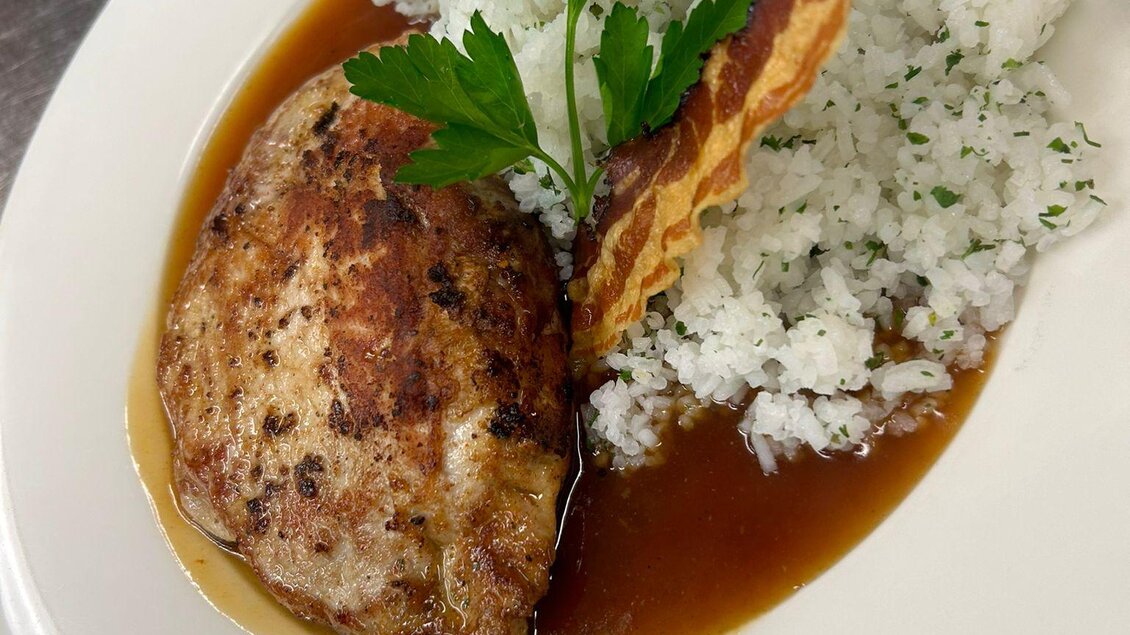 Zu sehen ist als Hauptspeise ein gefülltes Schweinsschnitzel am weißen Teller serviert.  | © Gasthaus Strobl
