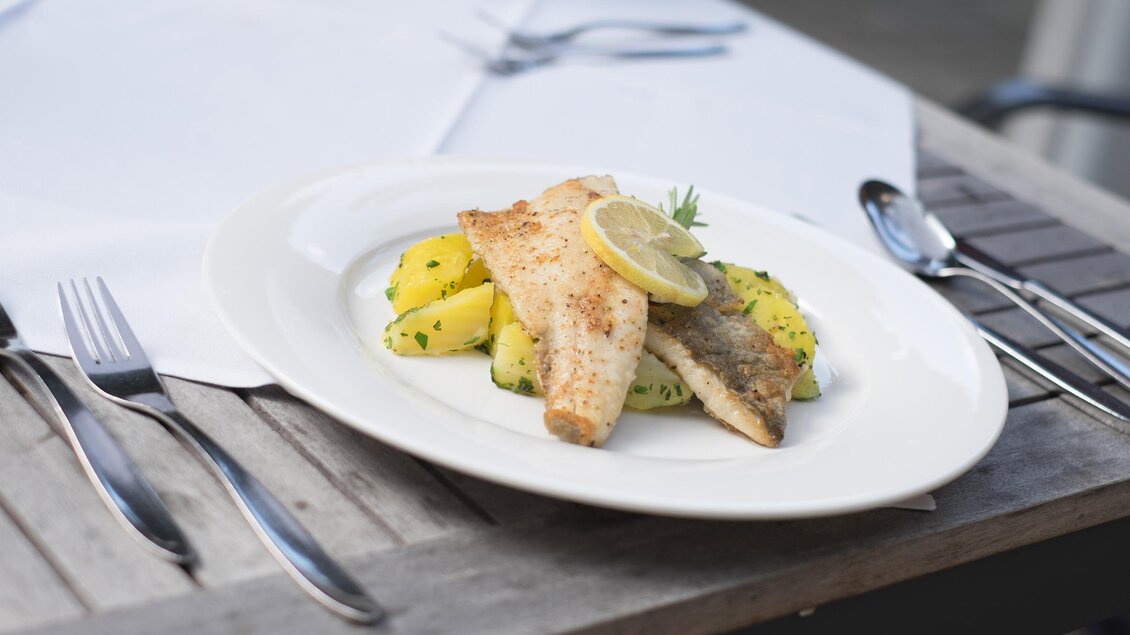 Zu sehen ist eine Hauptspeise mit Fisch und Kartoffeln.  | © Gasthaus Strobl