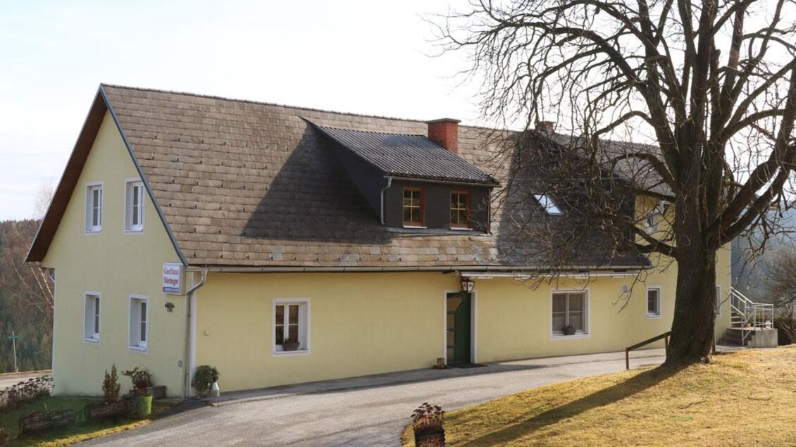 Gelbes Gebäude des Gasthauses Wartinger in Edelschrott mit Zufahrtsweg und großem Baum | © Steirische Rucksackdörfer