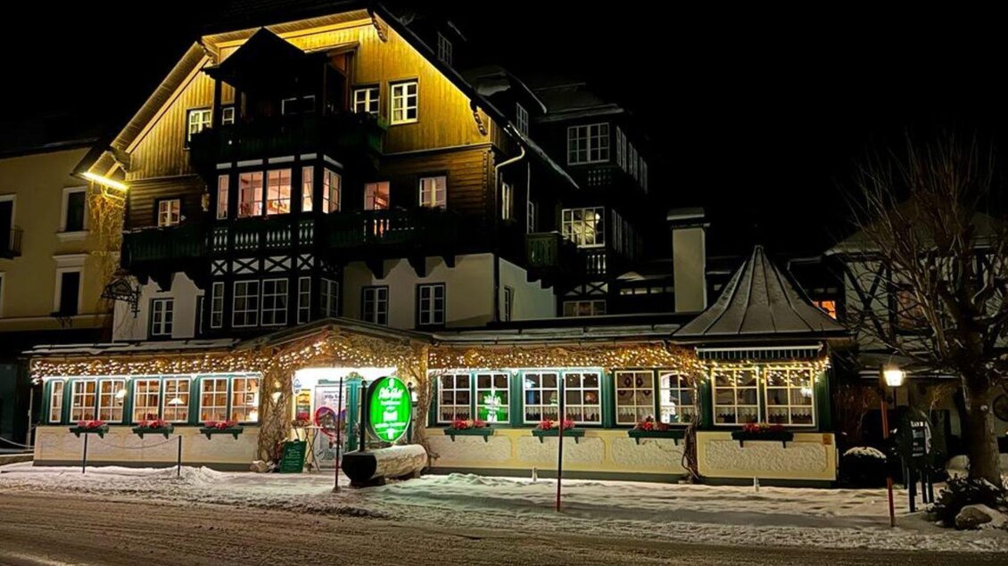 Ein schön beleuchtetes Gebäude im winterlichen Ambiente. Es ist nachts, und der Schnee liegt auf der Straße. | © Stephanie Bor