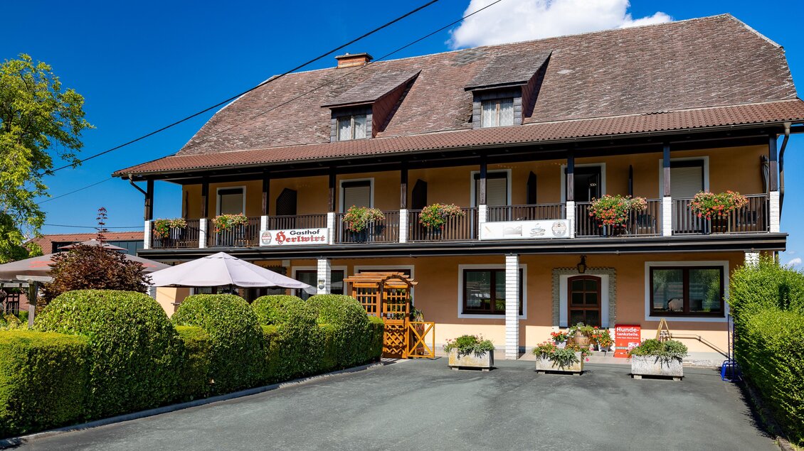 Außenansicht des Gasthofs Herlwirt in Ligist, Steiermark, mit Balkon, Blumenschmuck und Vorplatz. | © TV Region Graz - Harry Schiffer