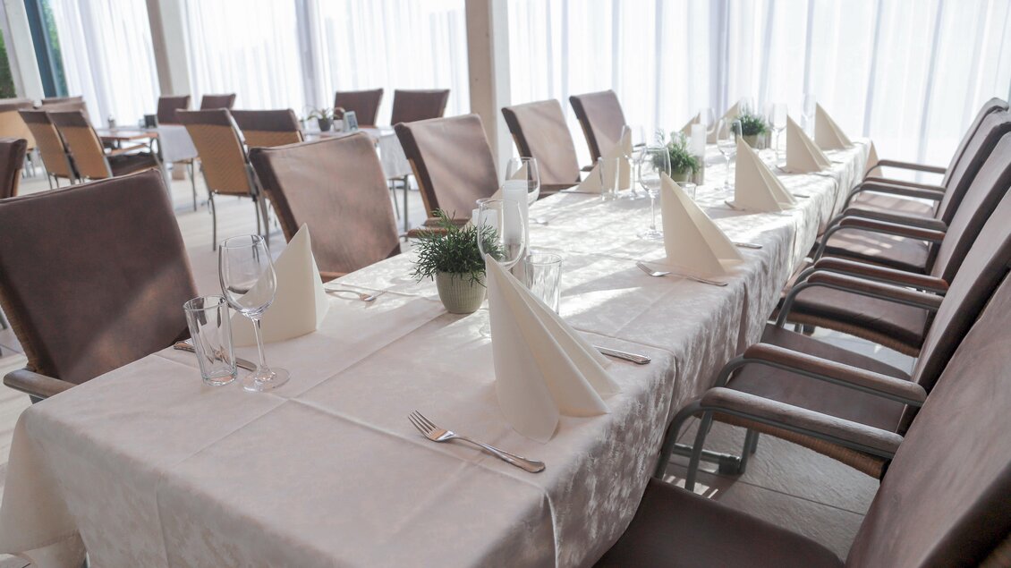 Ein elegant gedeckter Tisch in einem Restaurant. Die Stühle sind bereit für die Gäste und viel Tageslicht fällt durch große Fenster. | © Tourismusverband Oststeiermark