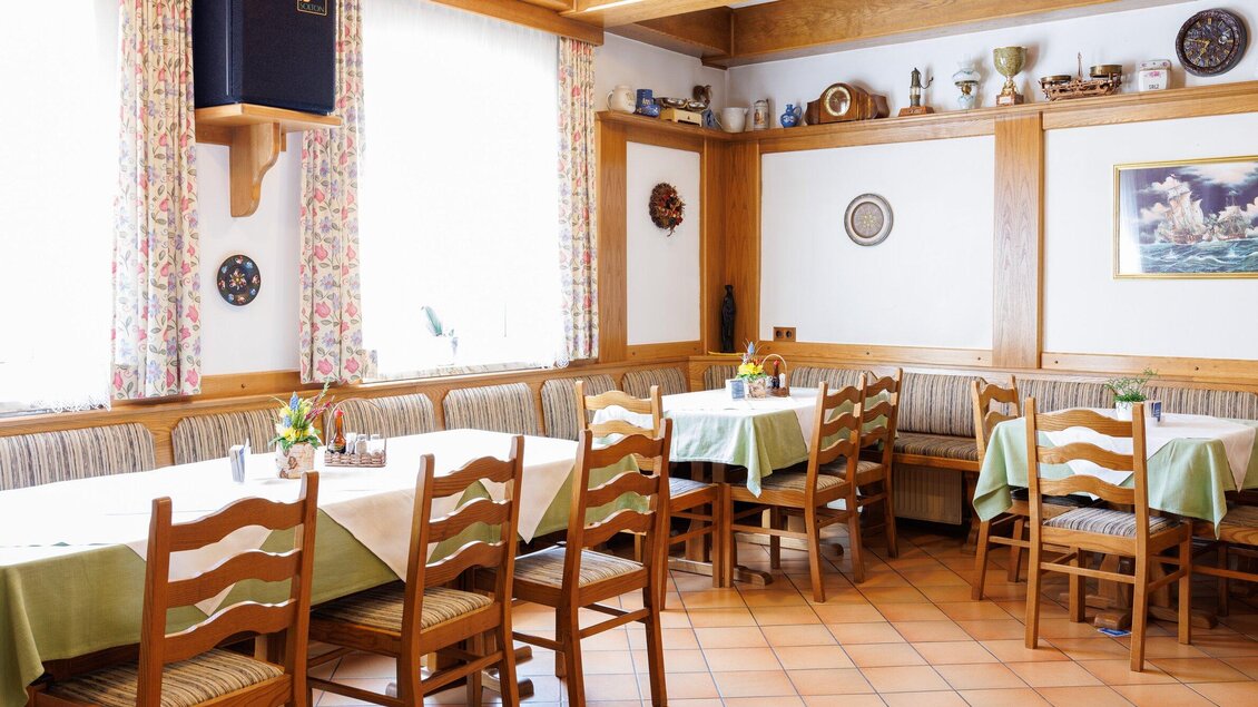Gaststube im Gasthaus Muralter in Voitsberg mit Holztischen, Stühlen, Eckbänken und gedeckten Tischen. | © TV Region Graz-Harry Schiffer
