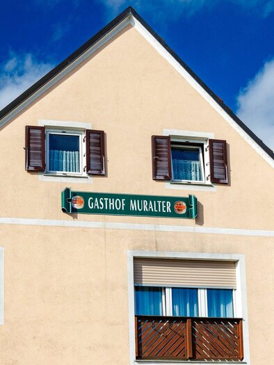 Fassade des Gasthauses Muralter in Voitsberg mit grüner Beschilderung und Fensterläden. | © TV Region Graz-Harry Schiffer