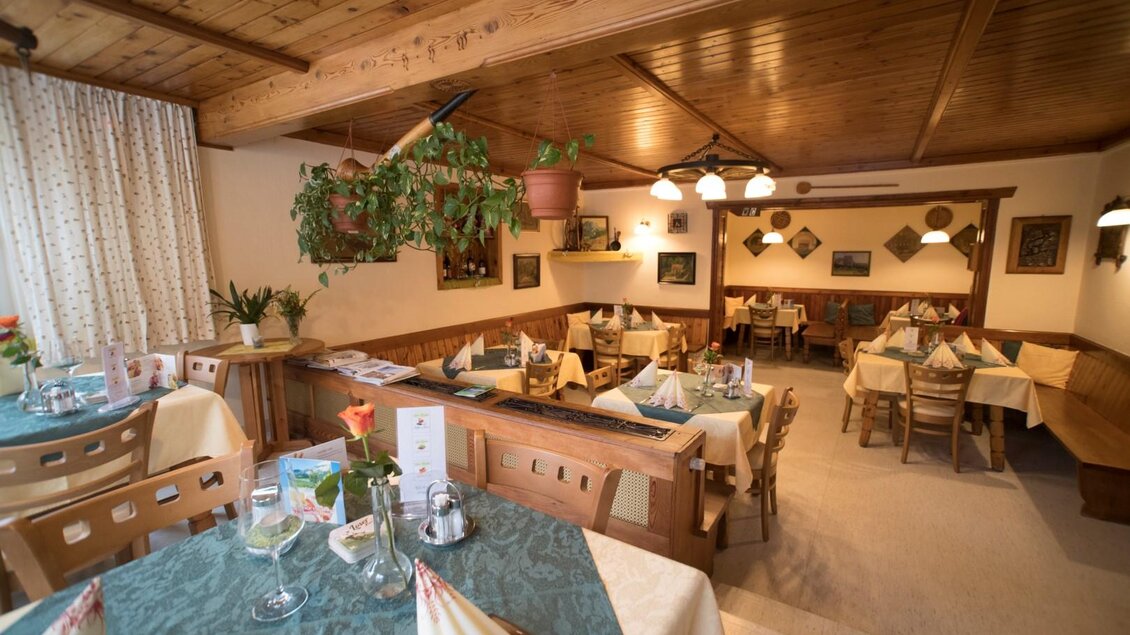 Ein gemütliches Restaurant mit Holzdekor und eleganten Tischen. Die Atmosphäre ist warm und einladend, ideal für ein entspanntes Essen. | © Gasthof Staud'nwirt