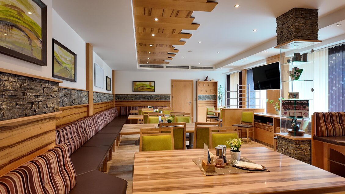 Ein gemütliches Restaurant mit Holzmöbeln und modernem Design. Die Wände sind mit Stein und Bildern dekoriert, und es gibt eine freundliche Atmosphäre. | © TV Hochsteiermark/Amelie Kertelits