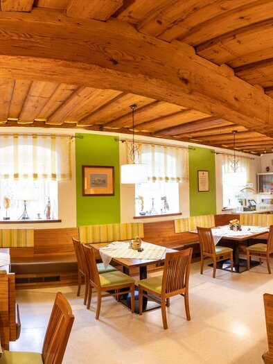 A cozy restaurant with wooden ceilings and bright colors. The tables are neatly set and the atmosphere is inviting. | © TV Region Graz - Lunghammer